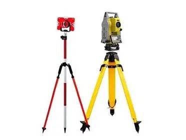 Total station on a tripod with a prism pole.