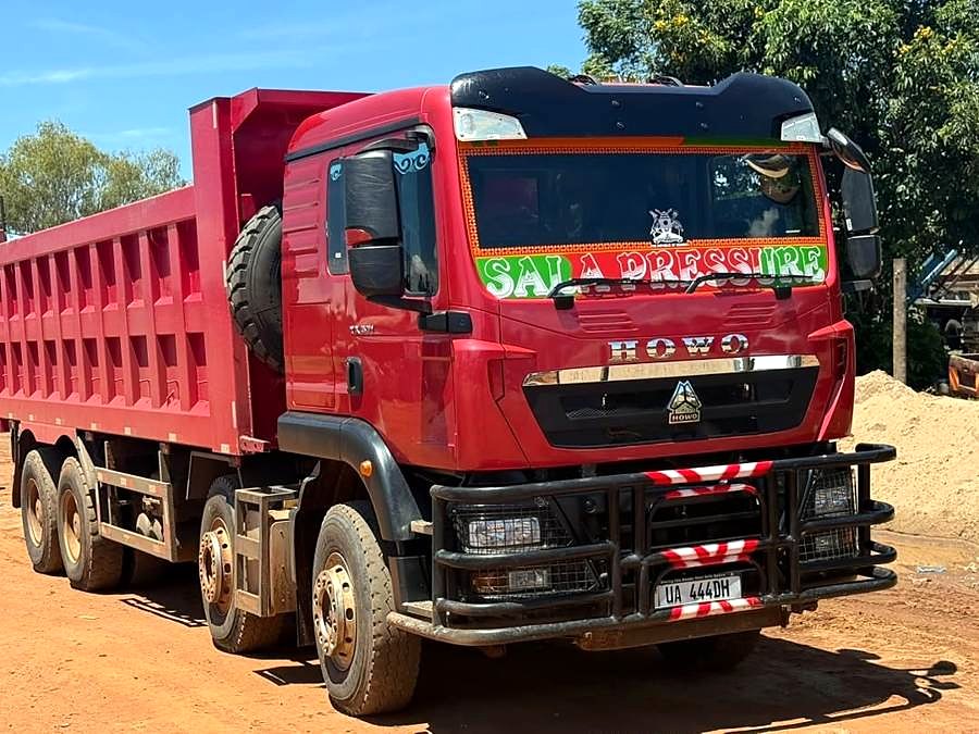 Red tipper truck on a gravel site.