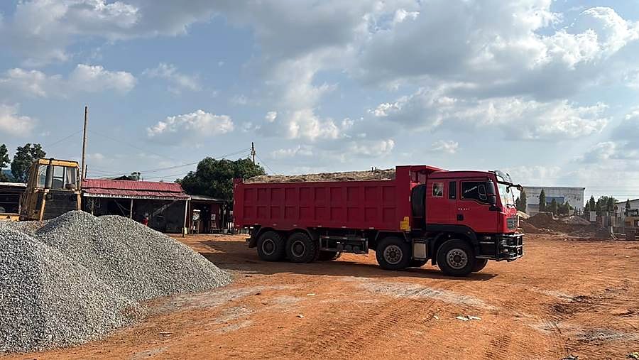 Red tipper truck at a gravel yard.
